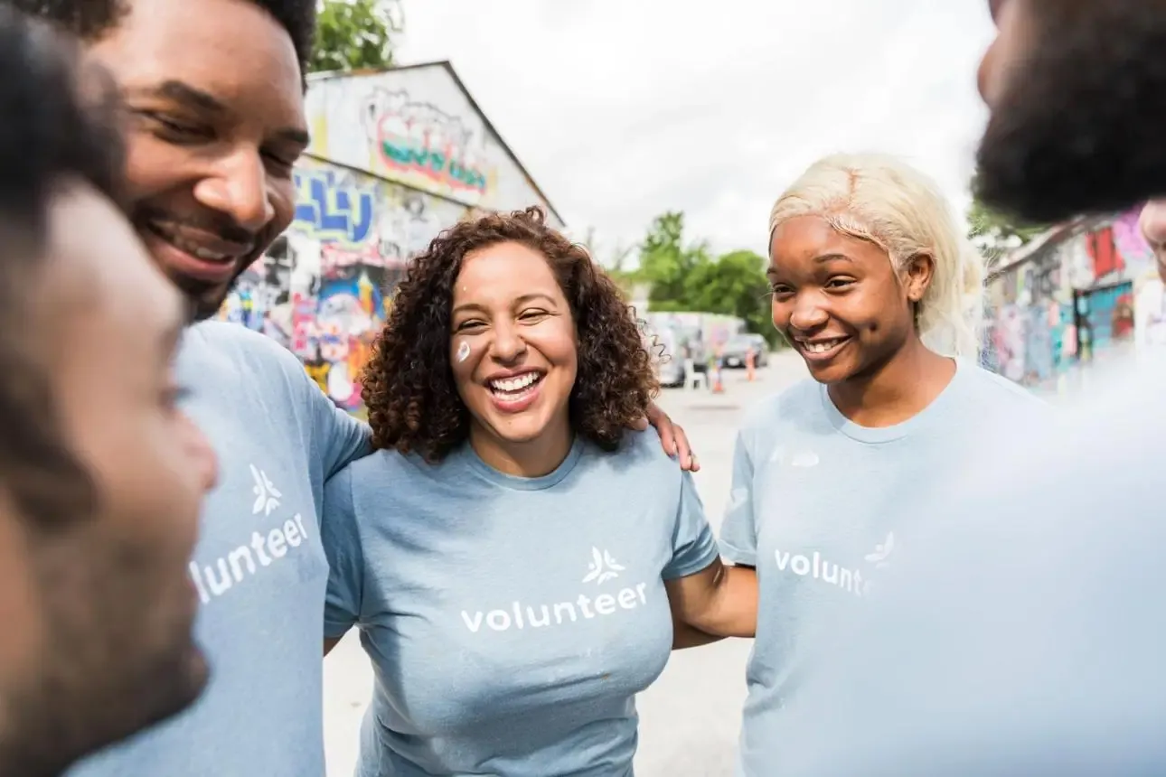 Smiling volunteers with their arms around each other